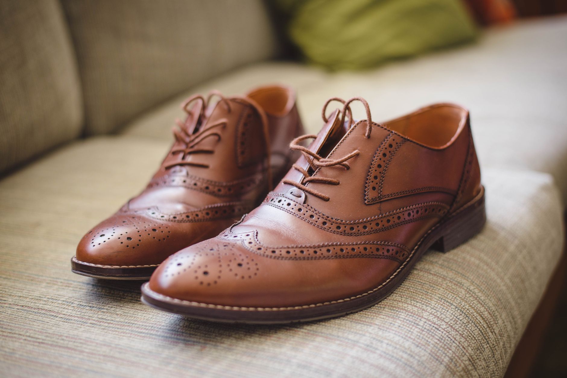 Élégante paire de chaussures marron en cuir pour hommes placée sur une surface grise à la maison