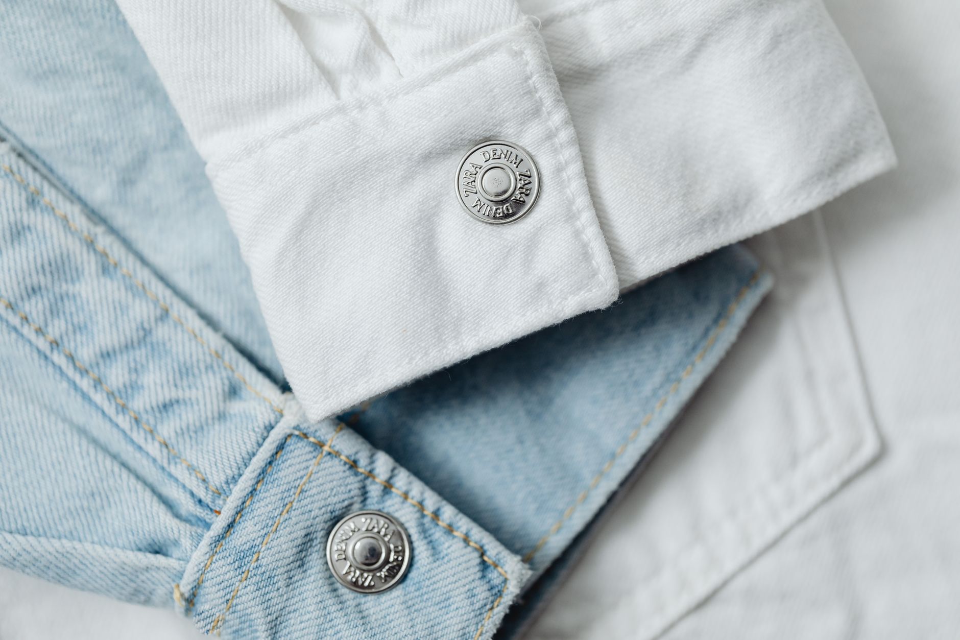 Gros plan sur un tissu en jean blanc et bleu clair stylé, mettant en valeur les détails et les textures.