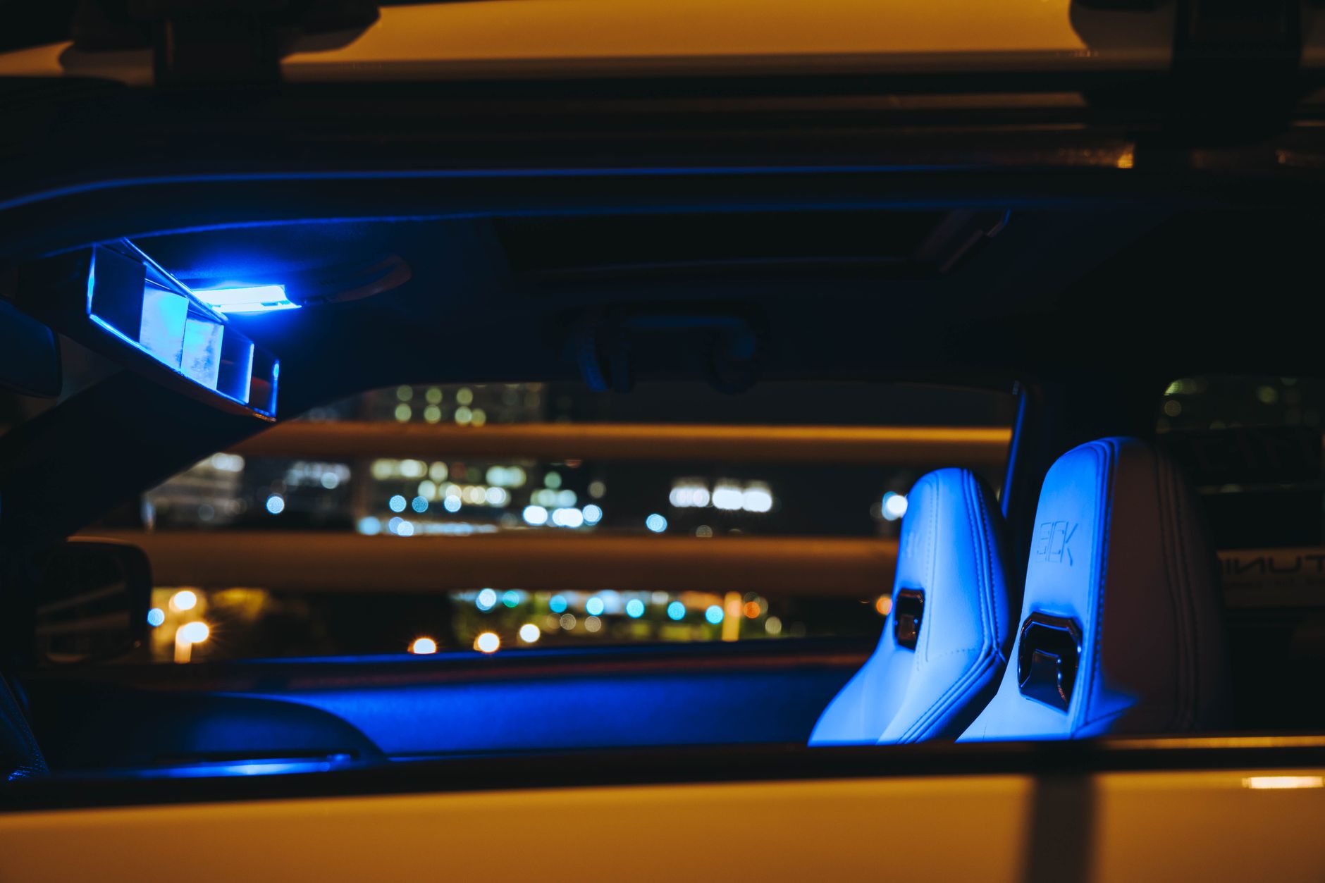 Habitacle d’une voiture illuminé par des lumières intérieures bleues de nuit.