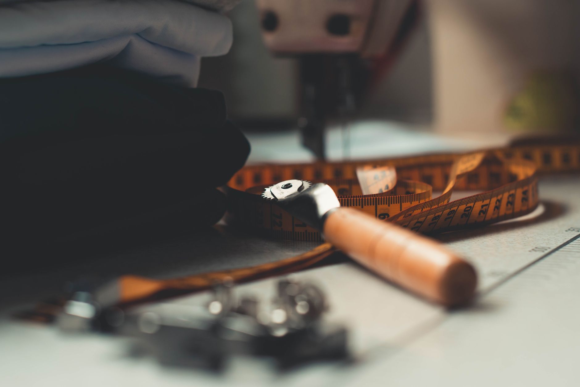 Mètre ruban et outil de couture posés sur l’établi d’un atelier